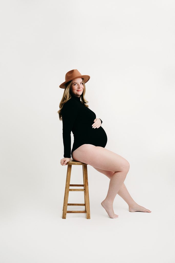 Mom poses on chair fine art maternity session holly marie photography