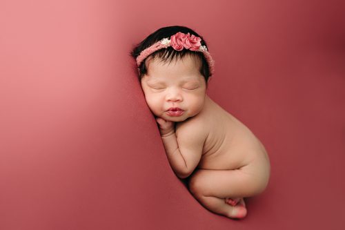 newborn girl on pink blanket photo session
