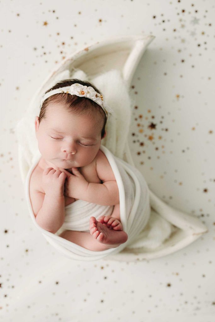 newborn girl sleeping in moon bowl holly marie photography