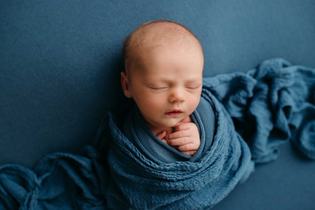 newborn boy swaddled in cheesecloth 