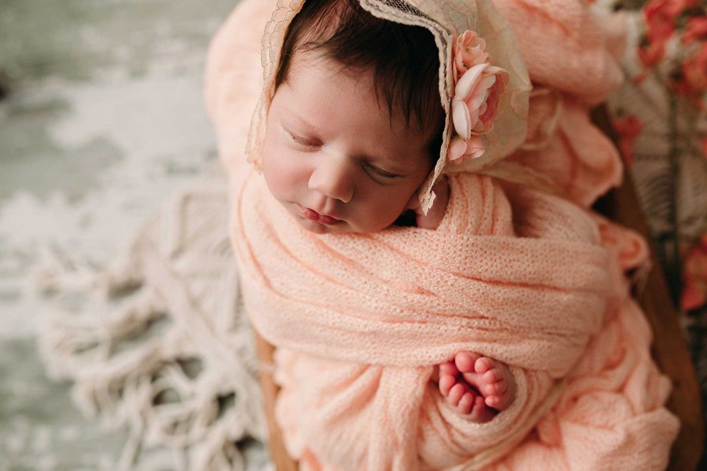 newborn in bonnet sleeping