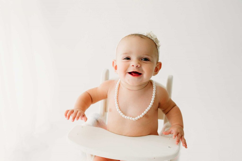 girl with pearls in high chair