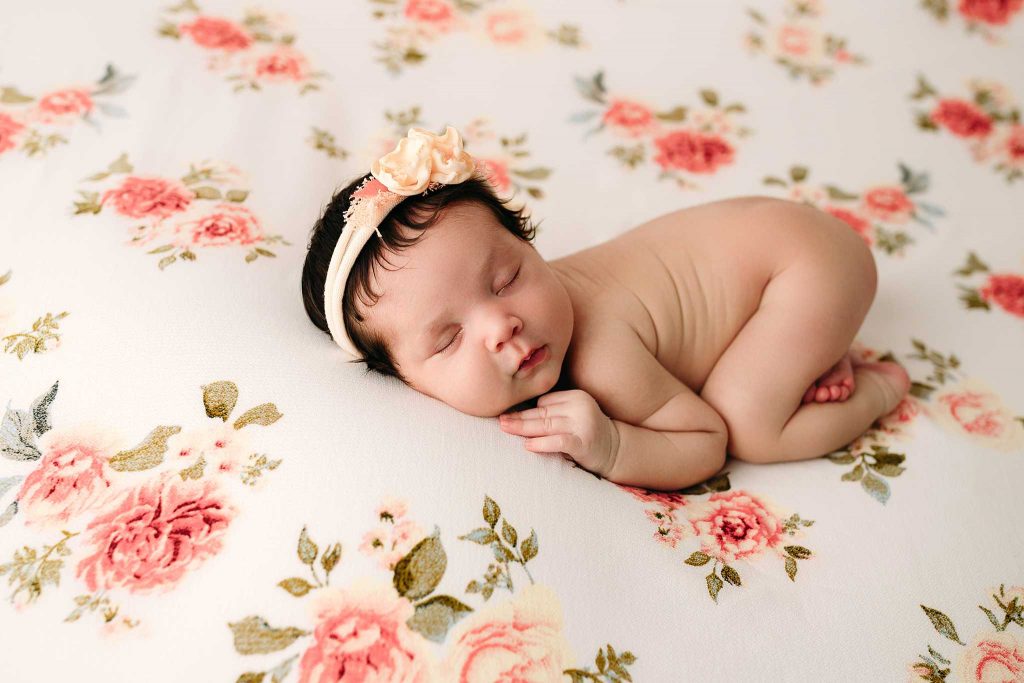 newborn girl sleeping on floral drop