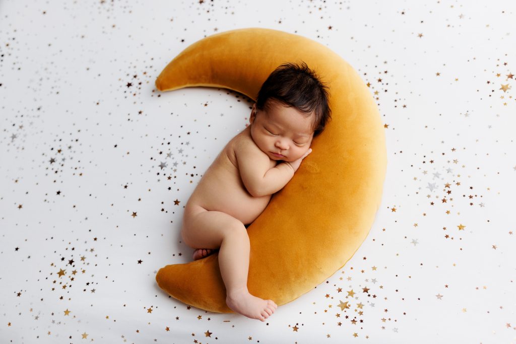 newborn boy sleeping golden moon with white star backdrop