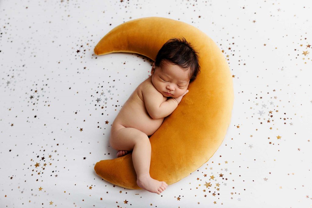 Newborn baby sleeping on moon pillow