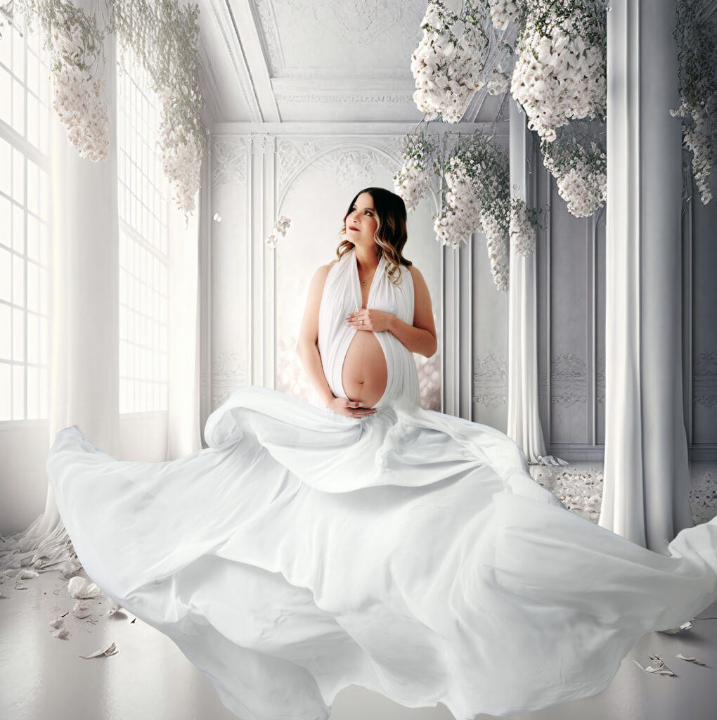 Fine art maternity portrait studio thrown white gown arches