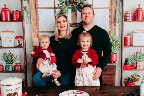 family dressed in red Christmas outfits in Christmas kitchen
