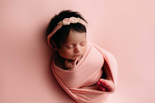 newborn wrapped on pink blanket