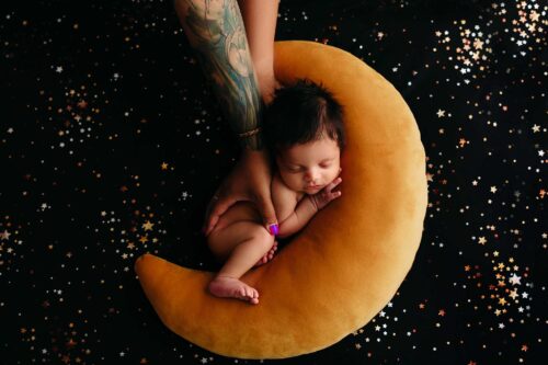 tattooed mom holds newborn son on blu emoon