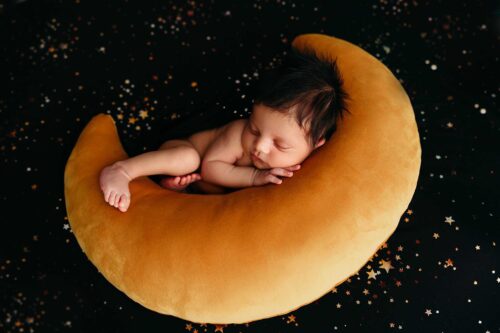 newborn boy sleeping on gold moon