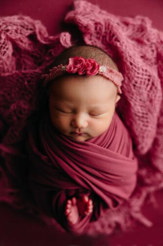 newborn girl swaddled toes peaking