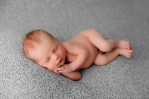 newborn boy swaddled side laying
