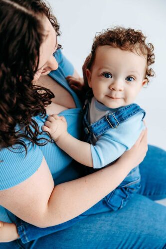 blue eye baby boy in demin on moms lap
