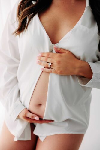 pregnant mom oversized white shirt holding belly
