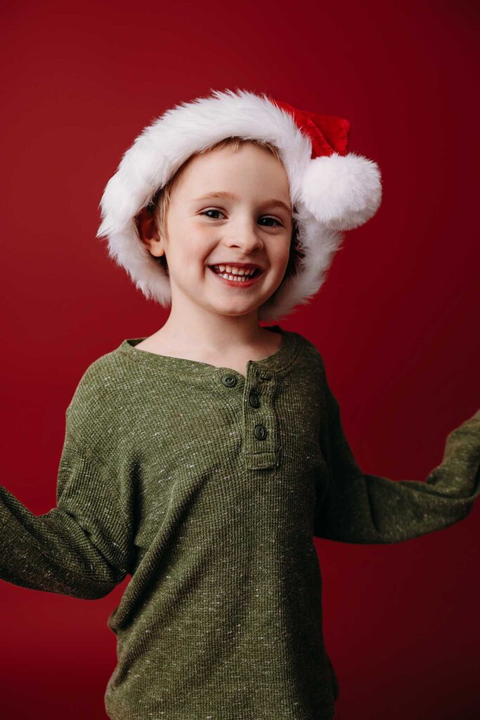 christmas red background boy wearing santa hat