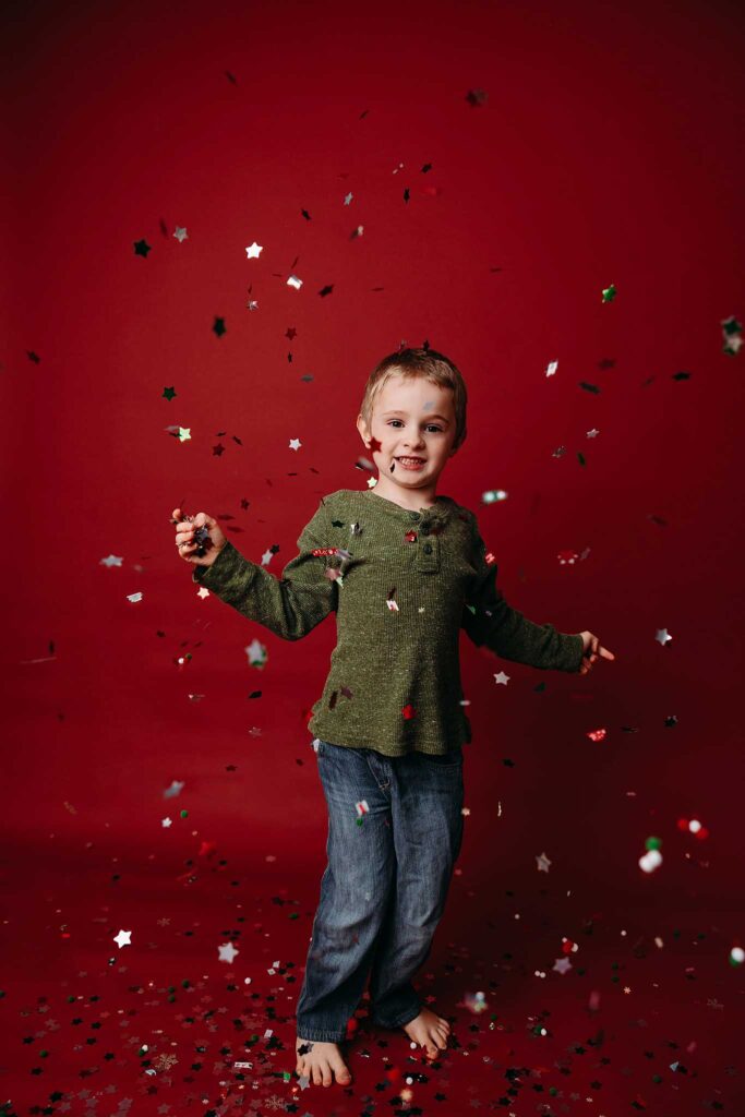 child throws christmas confetti